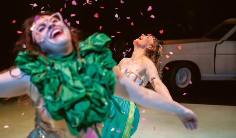 Photo de deux femmes costumées qui dansent sous une pluie de confettis