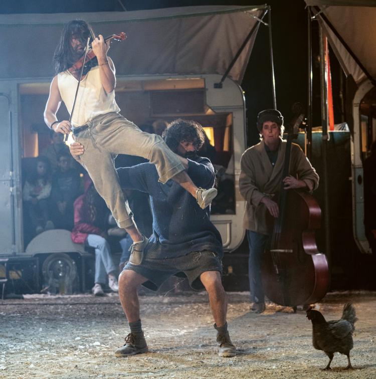 Photo de deux acrobates et une poule noire