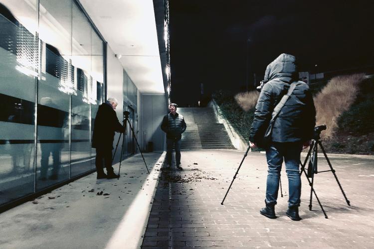 Photo de trois personnes en train de prendre des photos de nuit